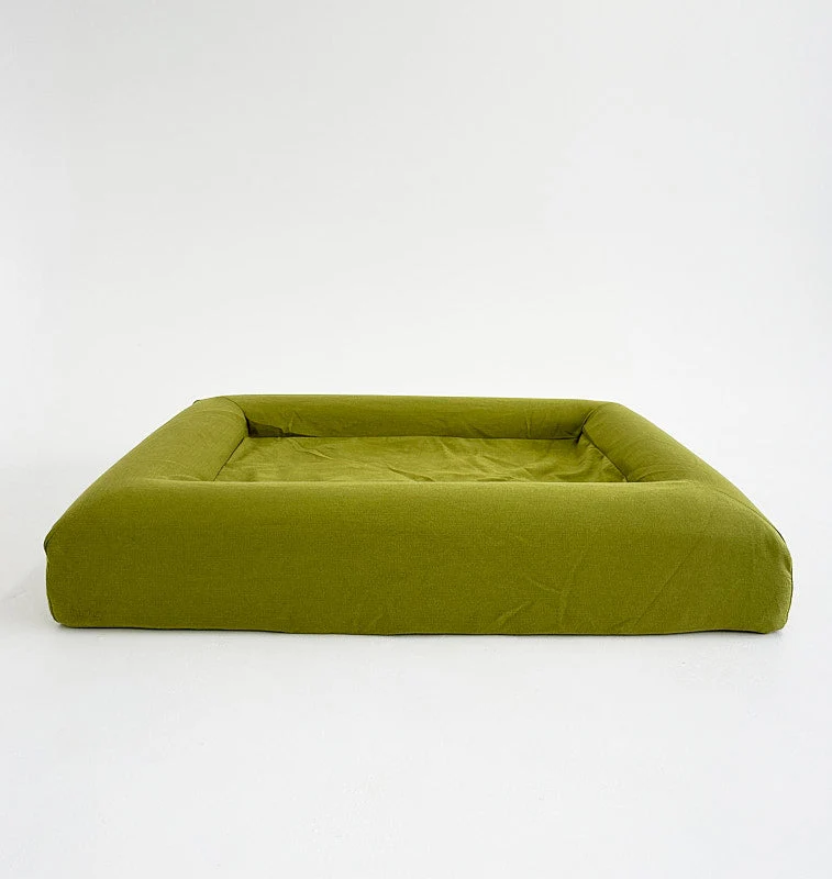 Basics Cover in Kiwi: the bed on its own from the front, a lime-green woven cover with bolsters on all four sides.
