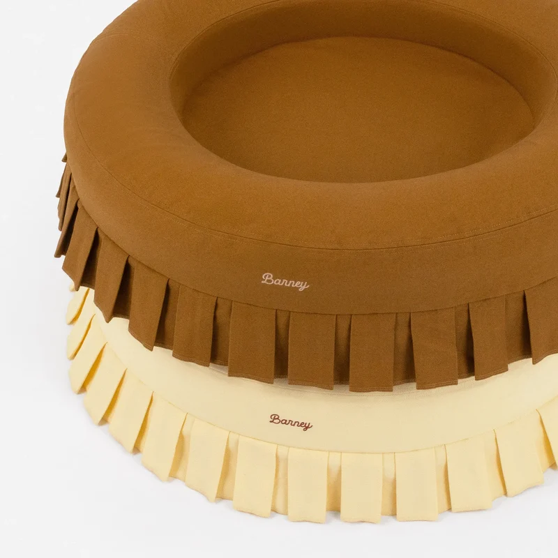 Nostalgia Cover Curl in Toffee and Buttercream: two round beds stacked, each with pleats and a script "Barney" logo.