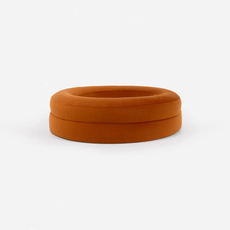 Velvet Cover Curl in Sunset on a BarneyCurl, from the side: a round burnt-orange velvet bed with a small "barney" label.