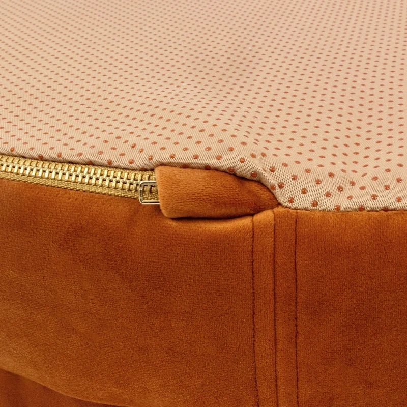 Velvet Cover Curl in Sunset: close-up of the brass zip end tucked under a velvet tab, beside the peach dotted base.