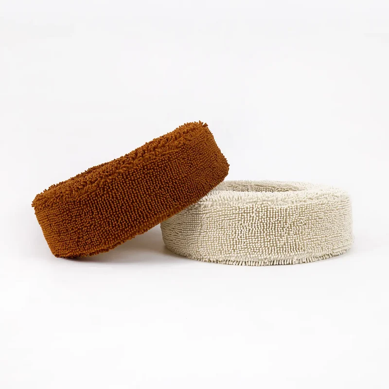 Barneycles Cover Curl in Fur Seal and Sugarloaf: a rust brown round chenille bed tilted against a cream one, on white.