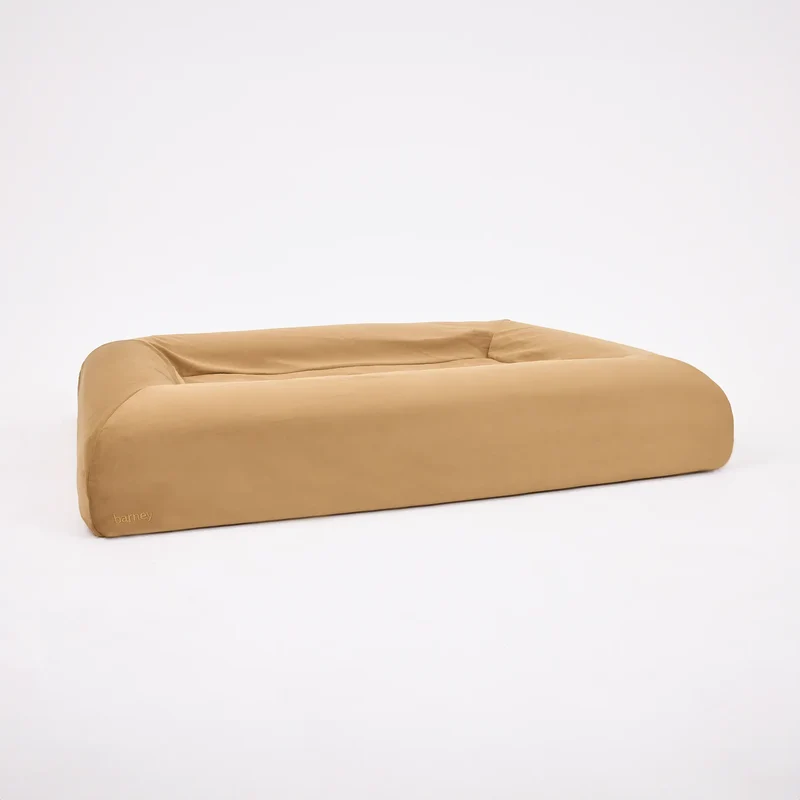 Butter Slip Cover in Peanut: a Barney Bed in the smooth caramel cover, seen from a corner on white.