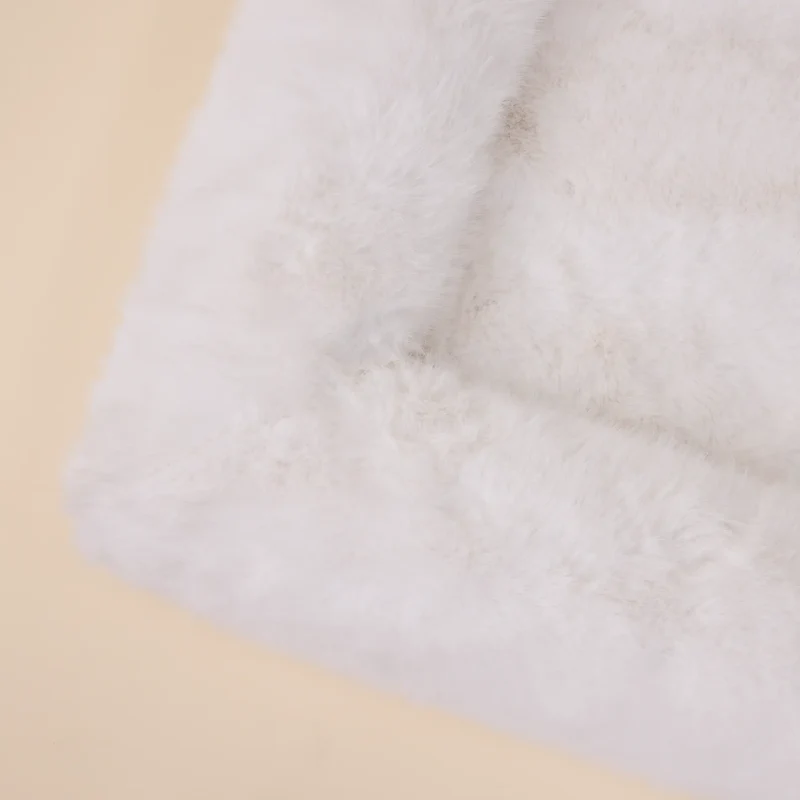 Fur Cover in Chibby: close-up of a corner from above, where the white faux-fur bolster meets the base.