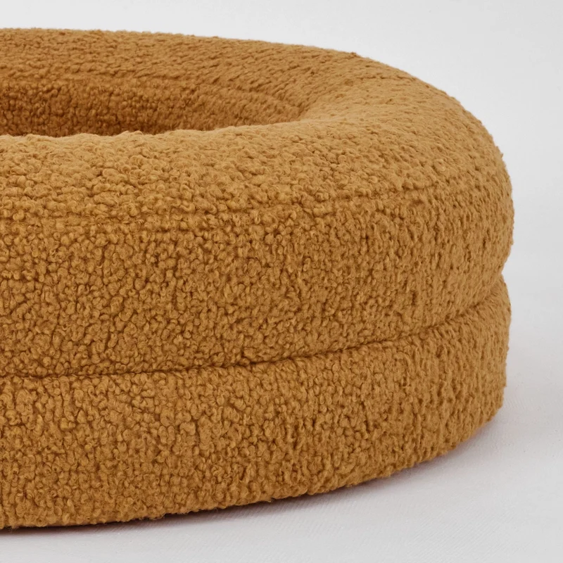 Dog bed in a warm golden colour with a soft, textured surface