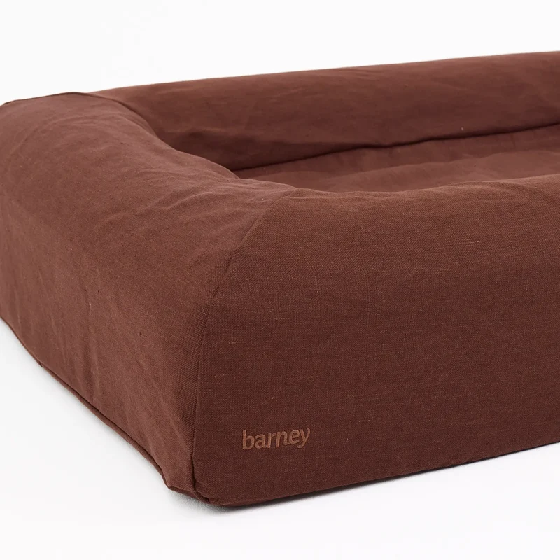 Linen Cover in Moose: close-up of a bolster corner, with a tone-on-tone "barney" on the chocolate brown linen.