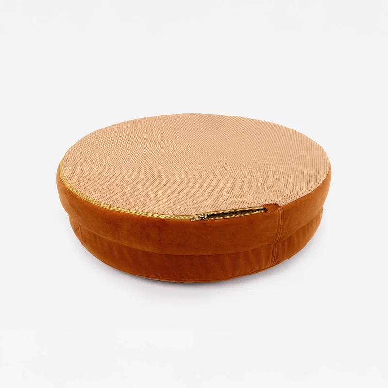 Velvet Cover Curl in Sunset, turned over: a peach base with orange non-slip dots and a brass zip around the edge.