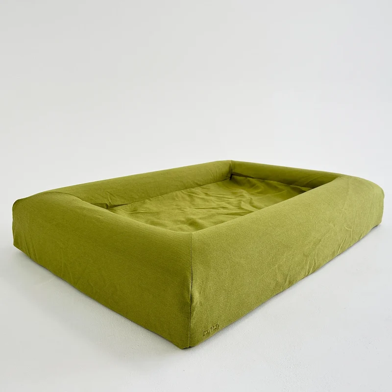 Basics Cover in Kiwi: the bed on its own, a lime-green woven cover with bolsters on all four sides.