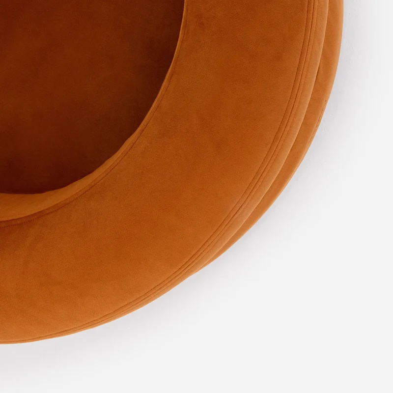 Velvet Cover Curl in Sunset: close-up from above of the curved burnt-orange velvet rim and its seams.